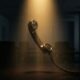 A classic vintage telephone receiver dangling off the hook in a dark, atmospheric room with golden light reflecting on its surface.Featured Image Description: A cinematic 1:1 conceptual realism shot. A classic black telephone receiver dangles mid-air, suspended by its coiled cord from a desk that remains in deep shadow. The receiver is the central focus, caught in a single, sharp beam of warm golden light that highlights the dust motes in the air. The background is a minimalist, dark office environment with a polished surface that reflects the glowing light. The scene suggests a missed connection and a silent, empty space where a sale should be happening. No people or hands are in the frame.Featured Image Title: The Missed Connection