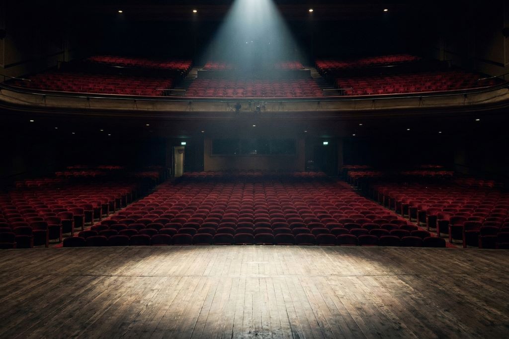 A single spotlight on an empty theater stage.
Featured Image Description: A cinematic, high-contrast photo of an empty luxury auditorium with a single spotlight illuminating a vacant wooden stage.
Featured Image Title: The Empty Stage of Business