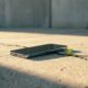 A high-end smartphone lying on a cracked concrete floor in a minimalist setting.
Featured Image Description: A cinematic photograph of a sleek, modern smartphone resting on a weathered, cracked urban surface. A single green sprout grows from a crack nearby, symbolizing the contrast between technology and neglect. Minimalist and realistic.
Featured Image Title: The Abandoned Digital Masterpiece