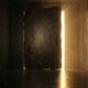 A heavy stone door standing slightly ajar to reveal a bright, golden light in a dark corridor.Featured Image Description: A cinematic 1:1 shot in conceptual realism. A massive, heavy stone door stands slightly ajar on its own in a dark, atmospheric concrete corridor. From the opening, a powerful, warm golden light pours out, cutting through the darkness and illuminating the reflective floor. The light represents the wealth and opportunity found through visibility. The environment is minimalist and premium, with a sense of immense weight and significant breakthrough.Featured Image Title: Opening the Wealth Door