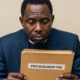 A Nigerian government official in an office holding a thick file folder representing The Scholarship That Never Left Asaba.