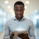 A focused Nigerian IT professional holding a glowing digital tablet representing the Vault of Digital Future with a completely blurred background.