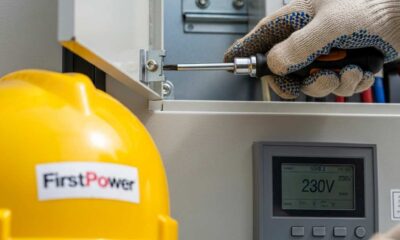 Close-up technician's gloved hand installing a cover on modern electrical switchgear.