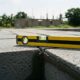 A yellow spirit level rests on a grey concrete block wall construction site