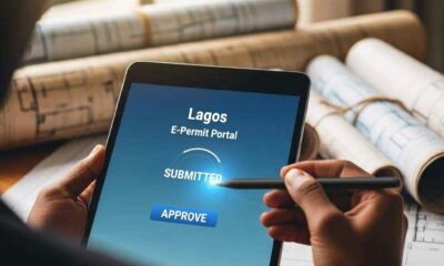 Hands using a tablet to approve a digital building permit.