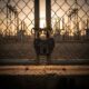 Rusted padlock on a chain-link fence at a Nigerian substation during sunset.