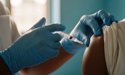 Close-up hands giving an injection into a person's arm sunlit clinic.