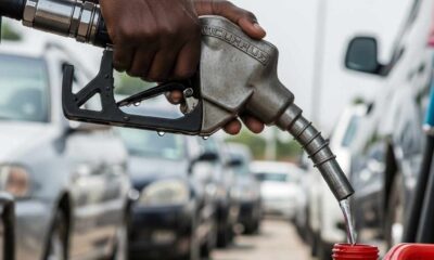 Close-up pumping fuel into an overfilled jerrycan busy station.