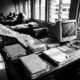 ghost workers Nigeria civil servant desk with personnel files and payroll documentsFeatured Image Description:
Interior photograph of a Nigerian government office showing a wooden desk stacked with old personnel files, handwritten attendance registers, and a dusty computer monitor. Natural light streams through louvered windows. The scene captures the administrative backlog where ghost workers thrive.Featured Image Title:
ghost-workers-nigeria-civil-servant-office-desk