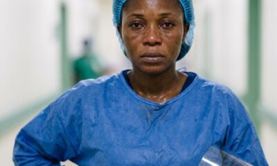 Nigerian nurse in full PPE standing outside Lassa fever isolation ward at federal medical centreFeatured Image Description:
Digital photograph of a female nurse in complete personal protective equipment including face shield, N95 mask, gown, and gloves. She stands outside a yellow-barricaded isolation ward at a federal medical centre. Morning light catches the condensation on her face shield. The background shows the corridor leading to high-containment area. Date stamp indicates March 2026.Featured Image Title:
healthcare-worker-ppe-lassa-fever-isolation-2026.jpg