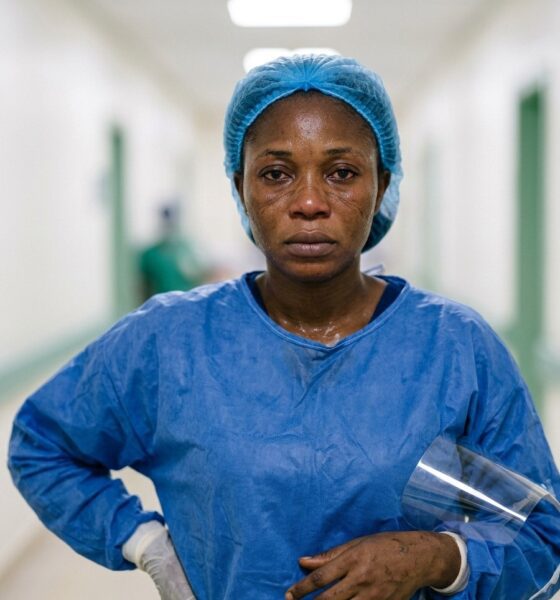 Nigerian nurse in full PPE standing outside Lassa fever isolation ward at federal medical centreFeatured Image Description:
Digital photograph of a female nurse in complete personal protective equipment including face shield, N95 mask, gown, and gloves. She stands outside a yellow-barricaded isolation ward at a federal medical centre. Morning light catches the condensation on her face shield. The background shows the corridor leading to high-containment area. Date stamp indicates March 2026.Featured Image Title:
healthcare-worker-ppe-lassa-fever-isolation-2026.jpg