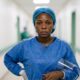 Nigerian nurse in full PPE standing outside Lassa fever isolation ward at federal medical centreFeatured Image Description:
Digital photograph of a female nurse in complete personal protective equipment including face shield, N95 mask, gown, and gloves. She stands outside a yellow-barricaded isolation ward at a federal medical centre. Morning light catches the condensation on her face shield. The background shows the corridor leading to high-containment area. Date stamp indicates March 2026.Featured Image Title:
healthcare-worker-ppe-lassa-fever-isolation-2026.jpg