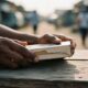 Close-up holding a cardboard mobile phone box on a weathered wooden table