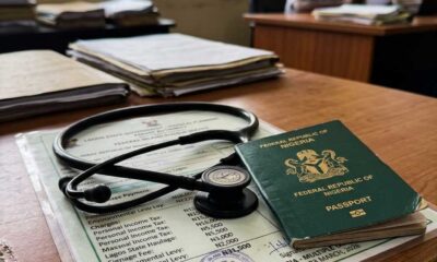 Close-up digital illustration of a dark green passport and a black stethoscope resting on an official tax document.