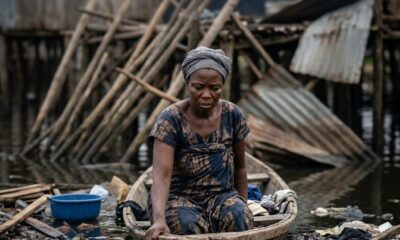 Makoko demolitions showing destroyed wooden structures on Lagos lagoon with personal belongings floating in waterFeatured Image Description:
Documentary photograph of Makoko waterfront community after demolition exercise. Broken wooden stilt houses collapse into Lagos lagoon. Roofing sheets and household items float among the debris. Several men in small wooden canoes paddle through the wreckage, attempting to salvage materials. Date stamp indicates first quarter 2026.Featured Image Title:
makoko-demolitions-lagoon-destruction-2026.jpg