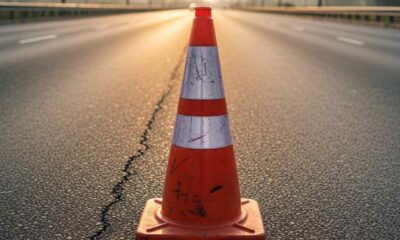 A single orange traffic cone on an empty Lagos highway at sunrise, symbolizing public order infrastructure.