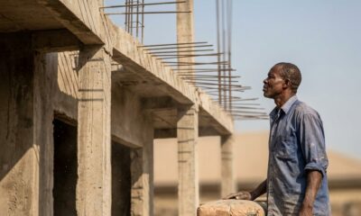 Real Estate Outlook 2026 Nigeria showing incomplete building structure with exposed reinforcement bars and blue sky backgroundFeatured Image Description:
Digital photograph of an abandoned residential building construction site in a Nigerian urban area. Concrete columns rise three floors with reinforcement rods rusting at the top. No workers present. Construction materials scattered below. Weeds growing around foundation. Taken in early 2026 during dry season. Represents stalled projects due to cost overruns.Featured Image Title:
real-estate-outlook-2026-abandoned-construction.jpg