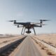 A commercial drone flying over a desert border road in Nigeria, illustrating new security challenges in 2026