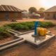 A new blue hand-pump borehole on a concrete platform in a rural Nigerian community under evening light.