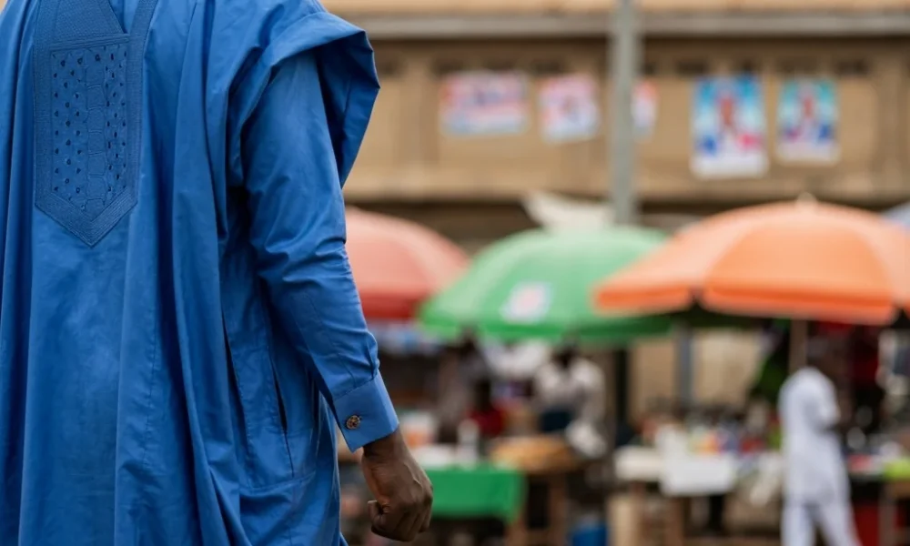 Person watches market. Back to camera.