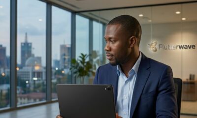 a professional Nigerian man (representing Olugbenga Agboola) seated in a sleek, modern office in Lagos. He is wearing a tailored navy blazer and focusing on a closed, minimalist laptop on his desk. The background is a clean, simplified view of the Lagos skyline under an evening sky. – Digitally synthesized: GoBeyondLocal.