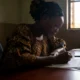 Woman in Nigeria filling out birth certificate application form