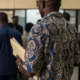 Man in Ankara shirt waits in line at FRSC office.