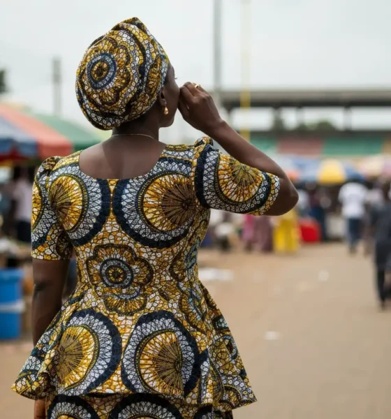 Woman on Lagos street listens to phone.
