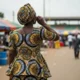 Woman on Lagos street listens to phone.
