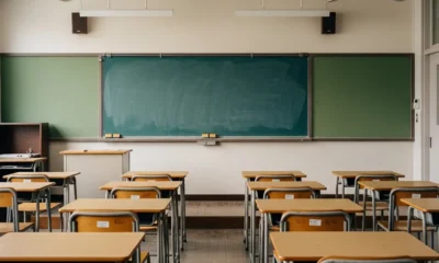 Empty classroom with desks and dusty chalkboard