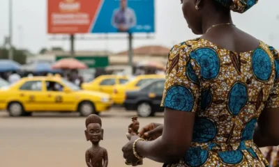 Woman looks at carving at outdoor market.