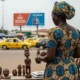 Woman looks at carving at outdoor market.