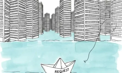 Paper boat navigates a sea of office buildings.