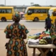 Woman at market in Nigeria looks at fabrics.