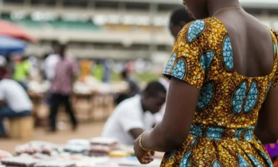 Woman at busy market stand.
