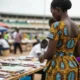 Woman at busy market stand.