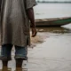Fisherman stands at the river's edge near the stark divide.